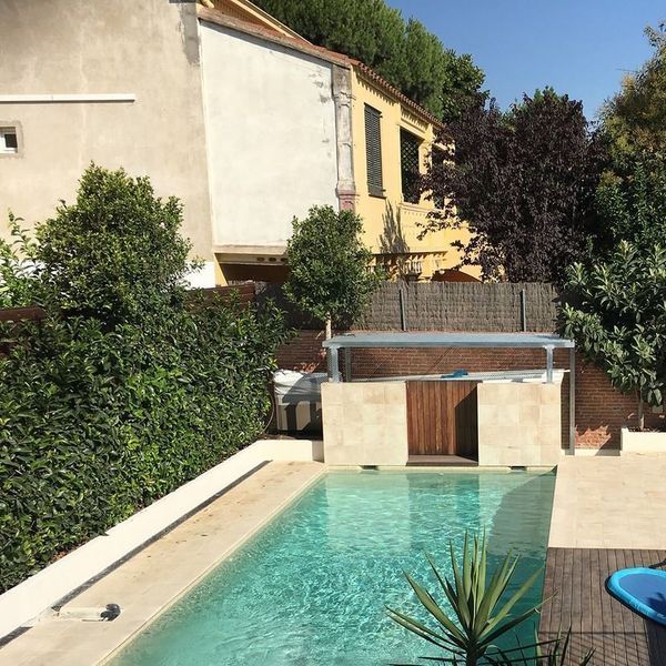 Una gran piscina con una casa al fondo.