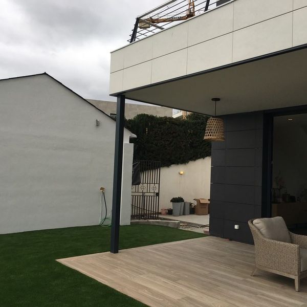 Una casa con un patio y una silla delante.