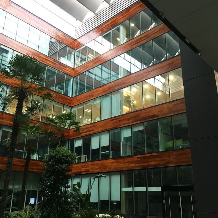 Un gran edificio con muchas ventanas y un árbol en el medio.