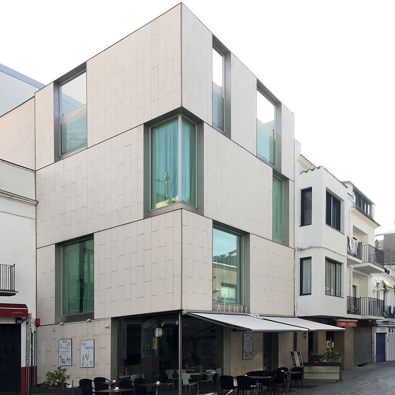 Un edificio con muchas ventanas, mesas y sillas.