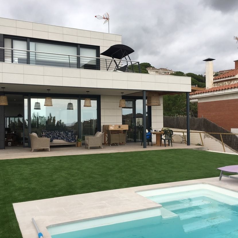 Una casa grande con piscina delante de ella.