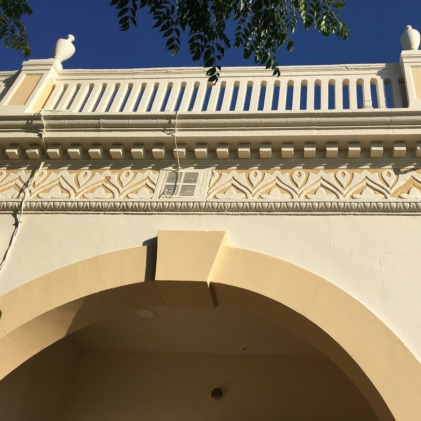 Un edificio con un balcón y un pájaro encima.