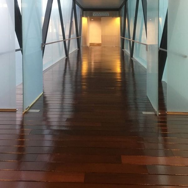 Un pasillo con suelos de madera y paredes de cristal.