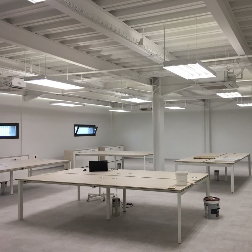 Una habitación grande con muchas mesas y sillas.