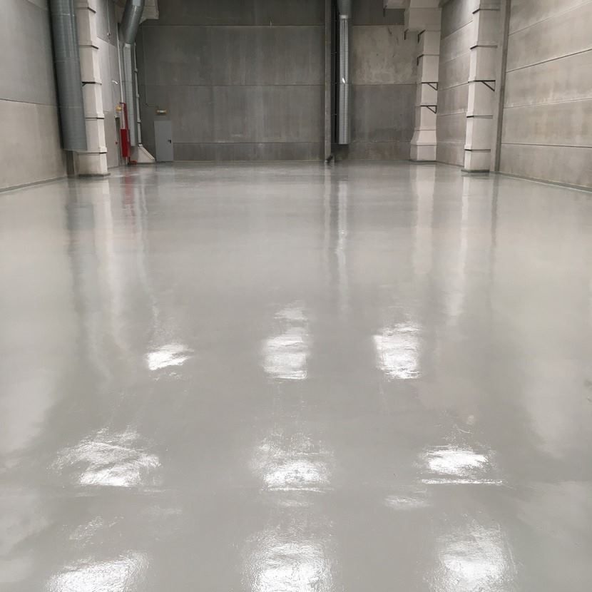 Un gran almacén vacío con un suelo de hormigón brillante.