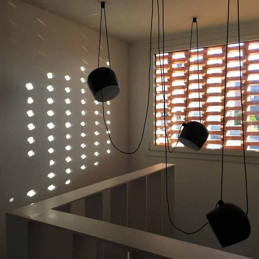 Una habitación con una ventana y algunas luces colgando del techo.