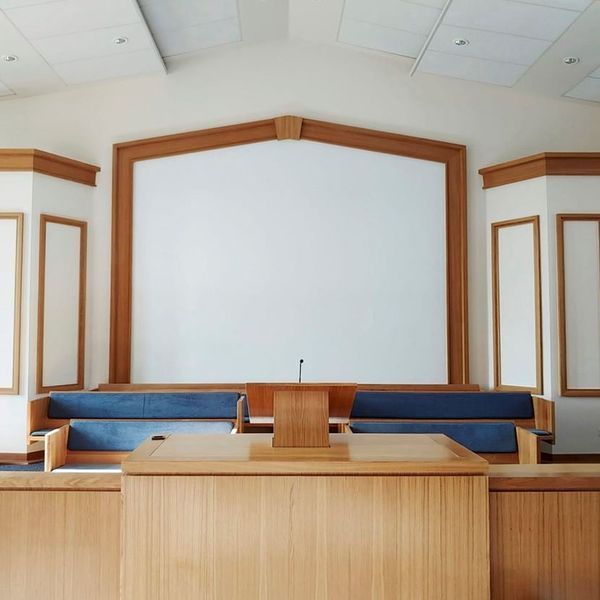 Una sala de audiencias vacía con un podio y sillas