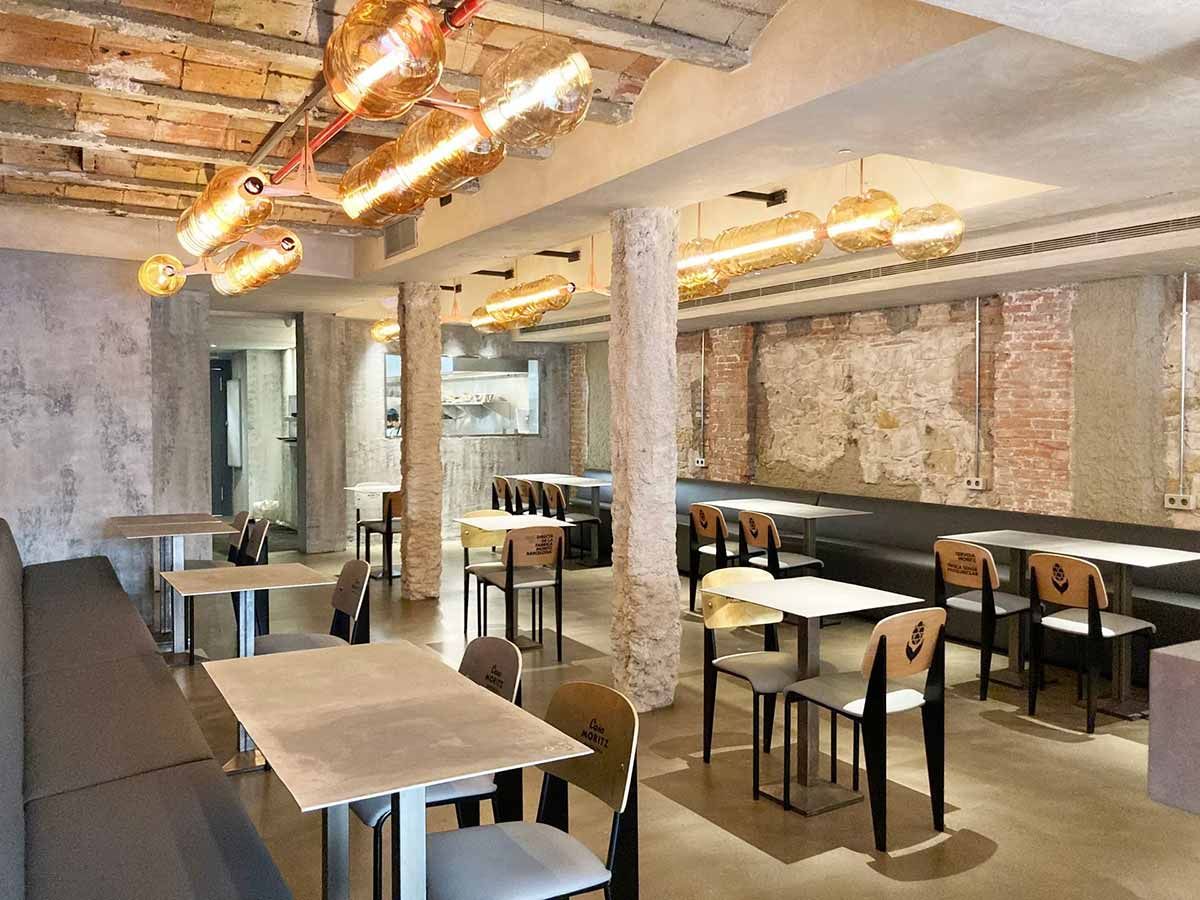 Un restaurante con mesas y sillas y una pared de ladrillos.