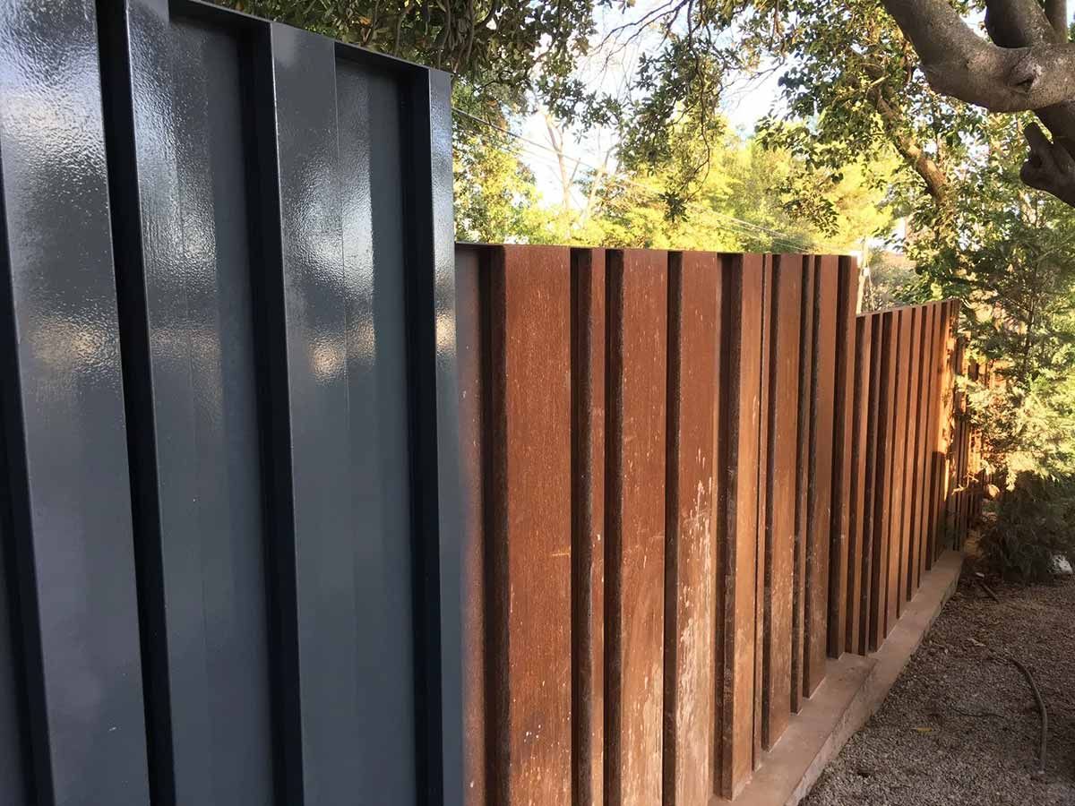 Un primer plano de una valla con un árbol al fondo.