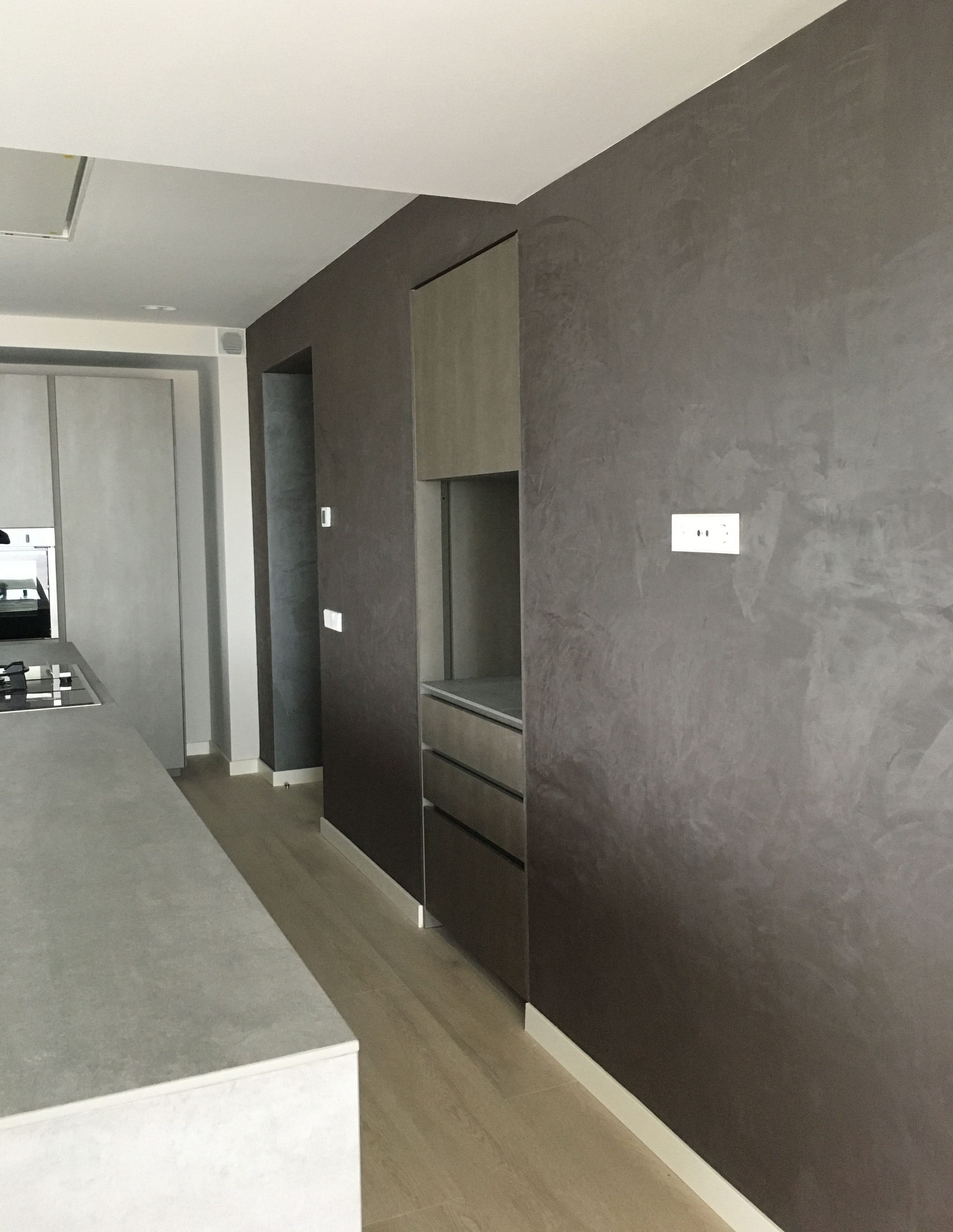 Una cocina con paredes marrones y suelos de madera.