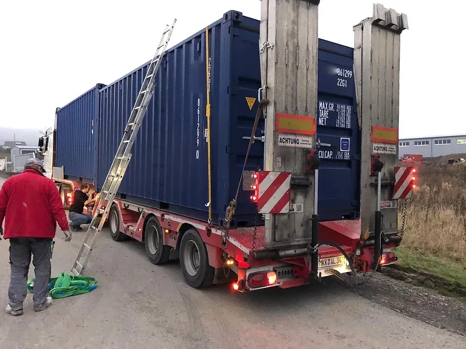 Ein Lastwagen transportiert einen blauen Frachtcontaine