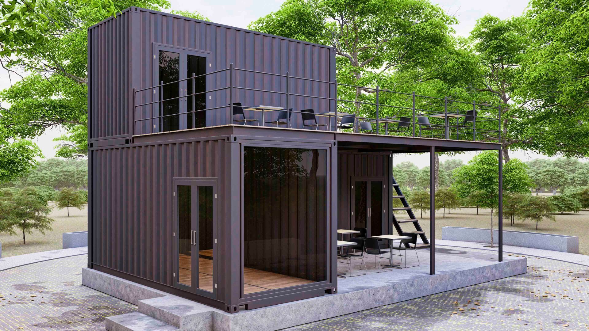 Zweistöckiges Containerhaus mit Sitzgelegenheiten im Freien und schwarzer Fassade in natürlicher Umgebung.