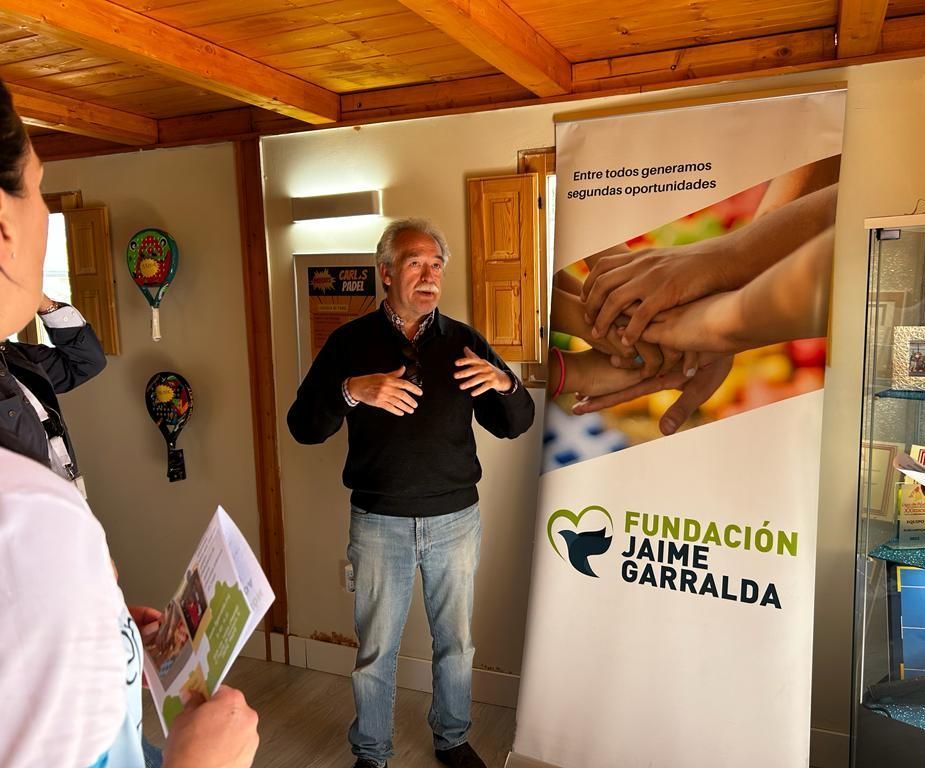 Un hombre está parado frente a un cartel que dice Fundación Jaime Garralda