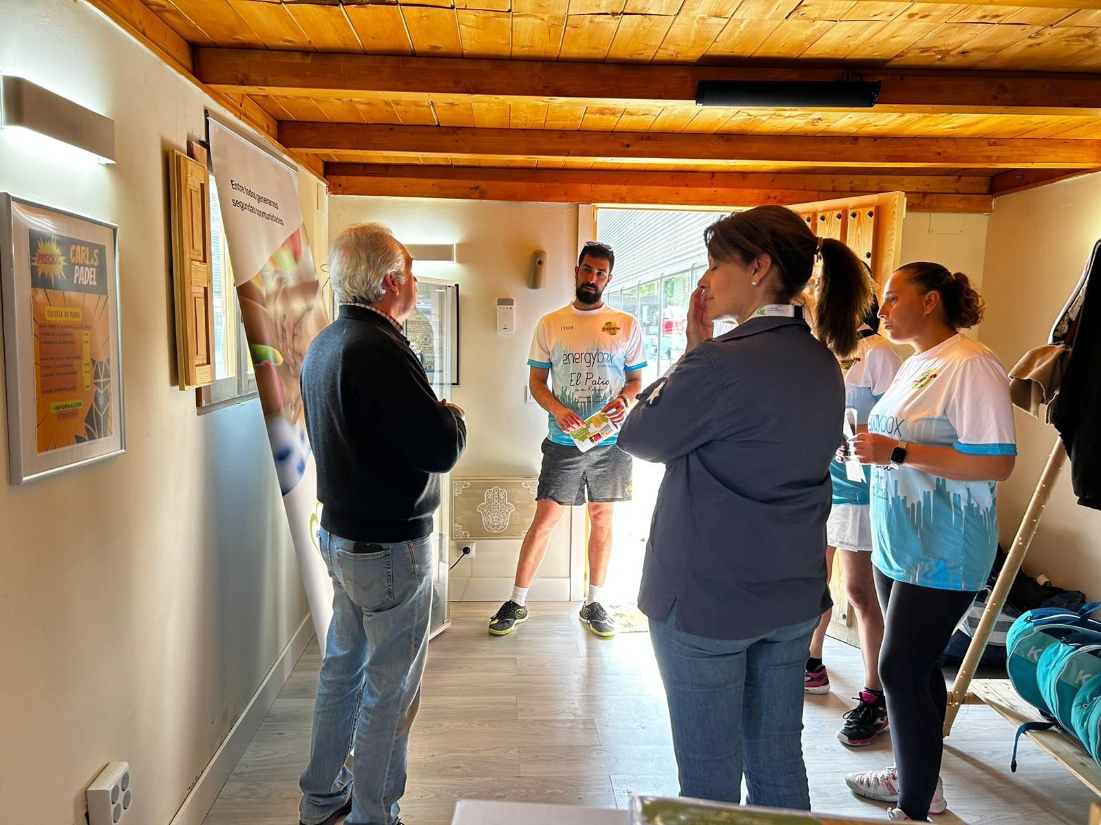 Un grupo de personas están de pie en una habitación hablando entre sí.