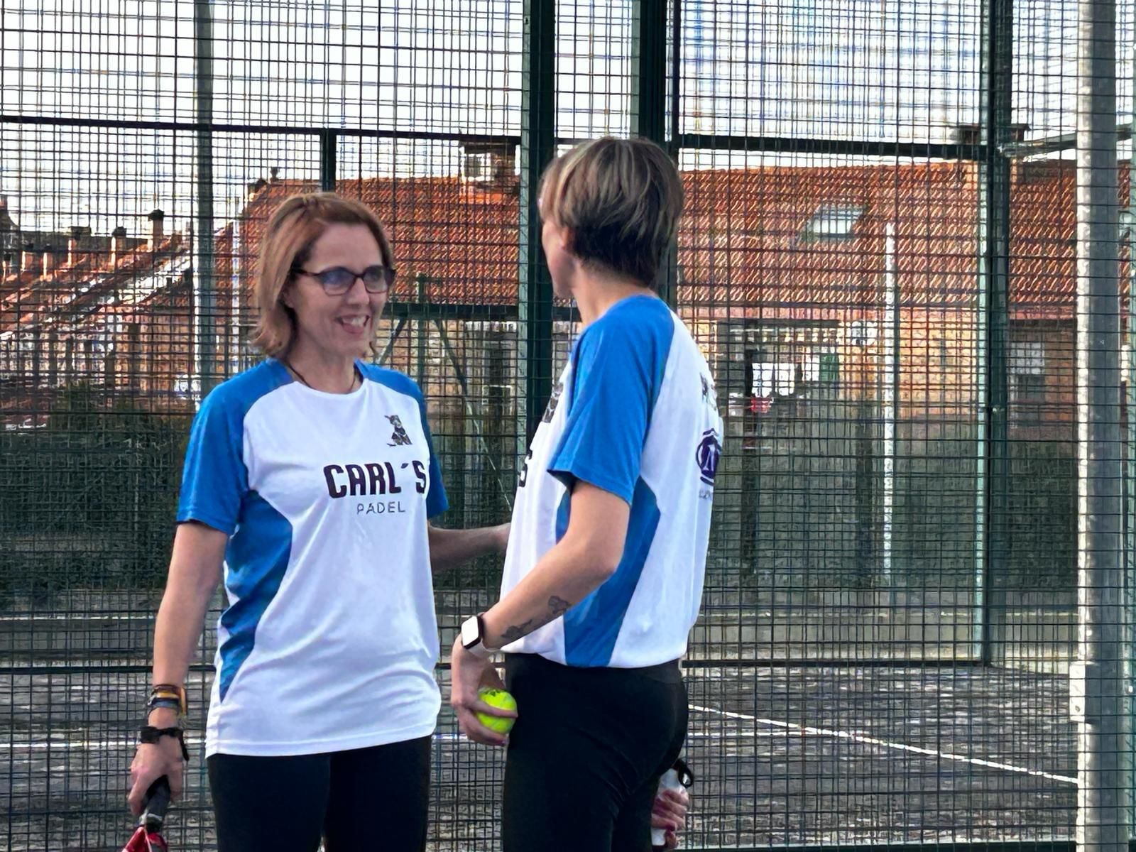 Dos mujeres están paradas una al lado de la otra en una cancha de tenis.