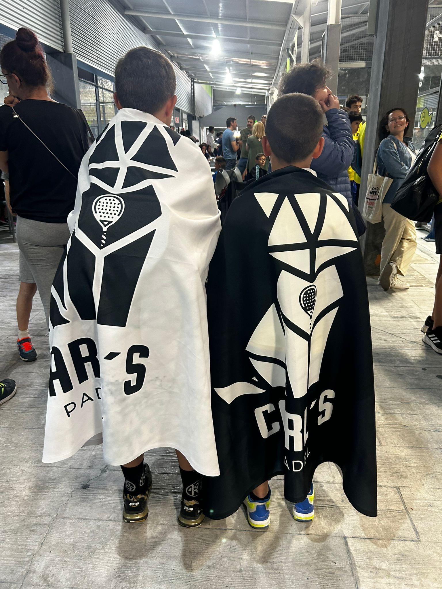 Dos jóvenes están parados uno al lado del otro y llevan capas.