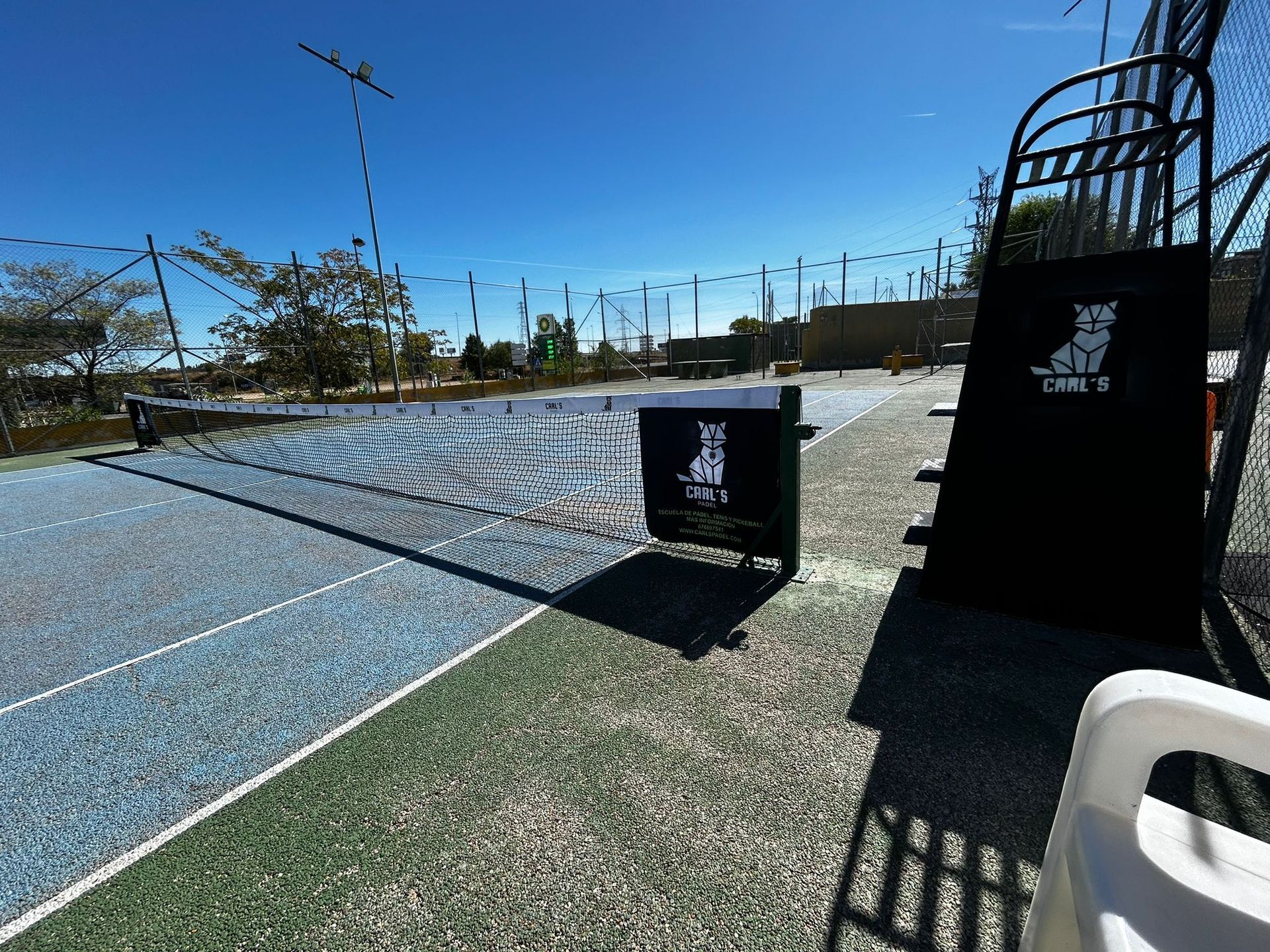 Una cancha de tenis con una silla delante de ella
