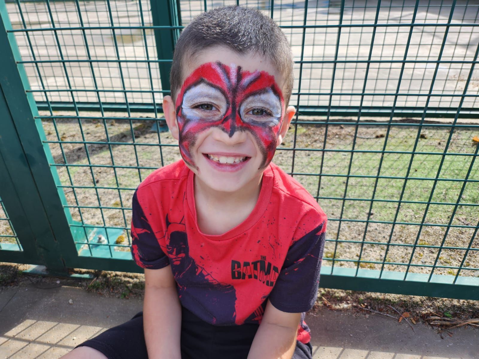 Un niño con la cara pintada como un hombre araña.