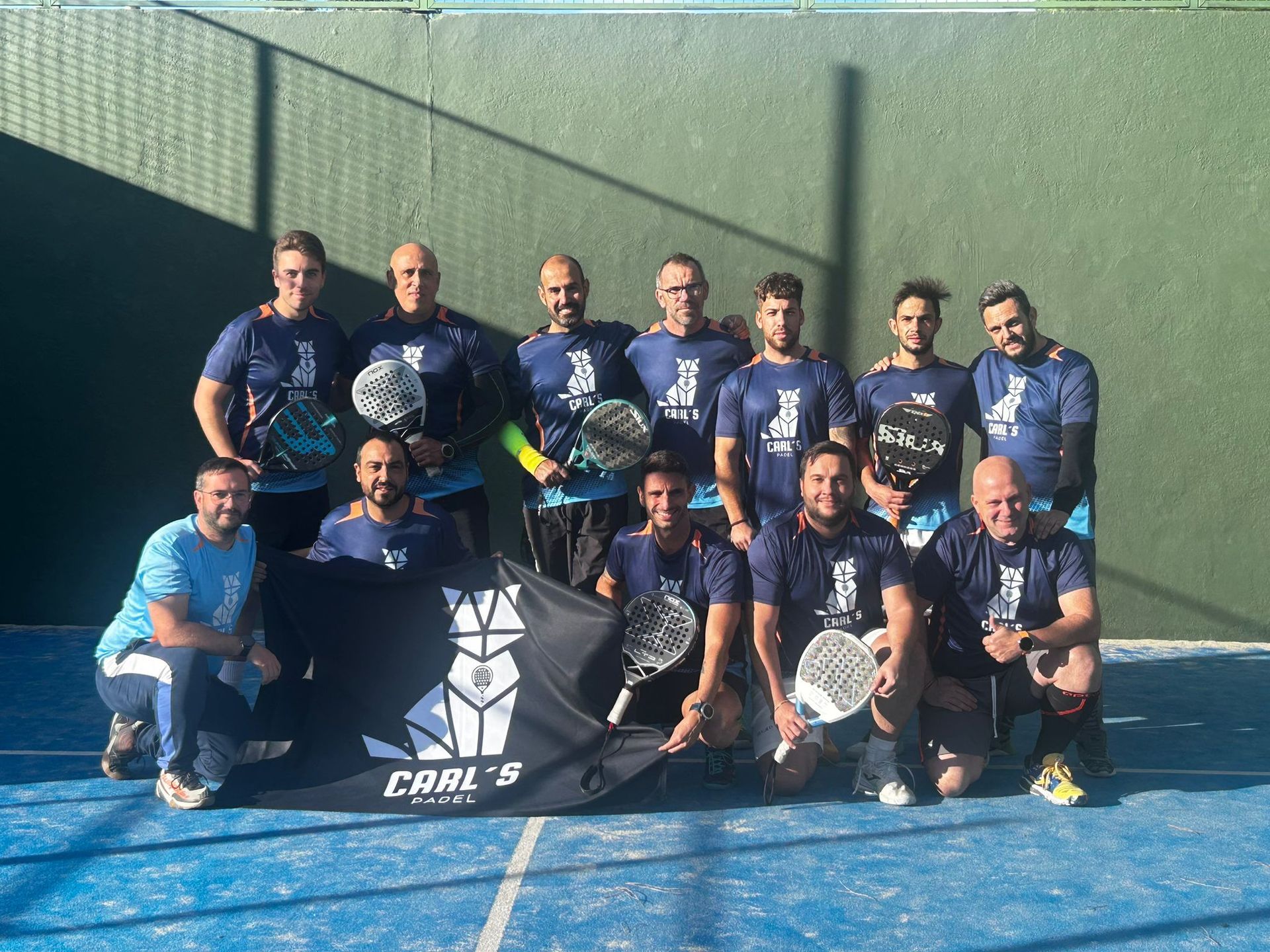 Un grupo de hombres posa para una fotografía en una cancha de tenis.