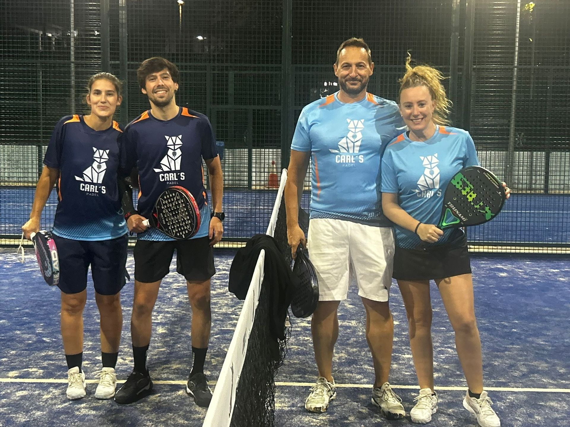 Un grupo de personas posa para una fotografía en una cancha de tenis.