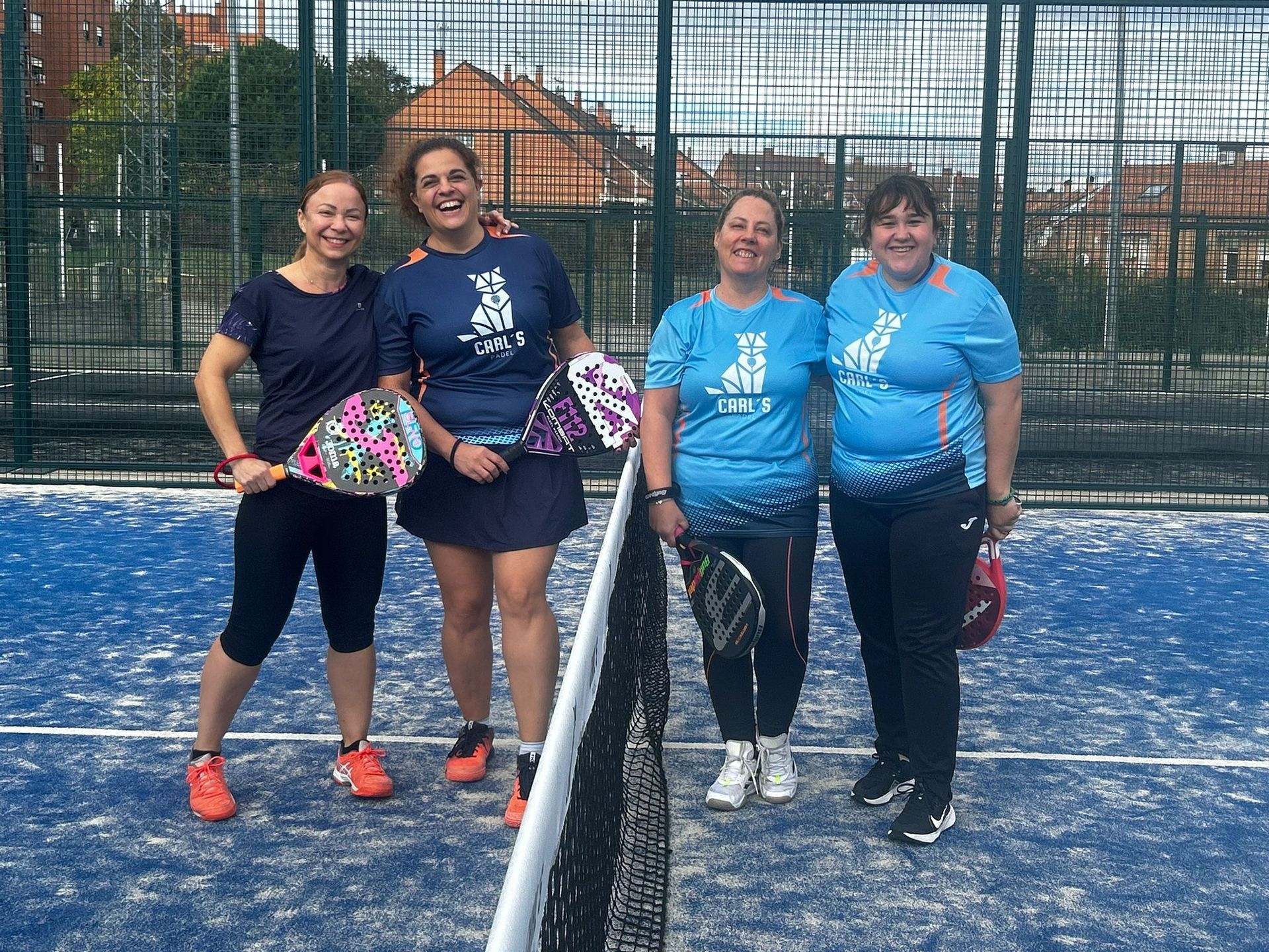 Un grupo de mujeres posa para una fotografía en una cancha de tenis.