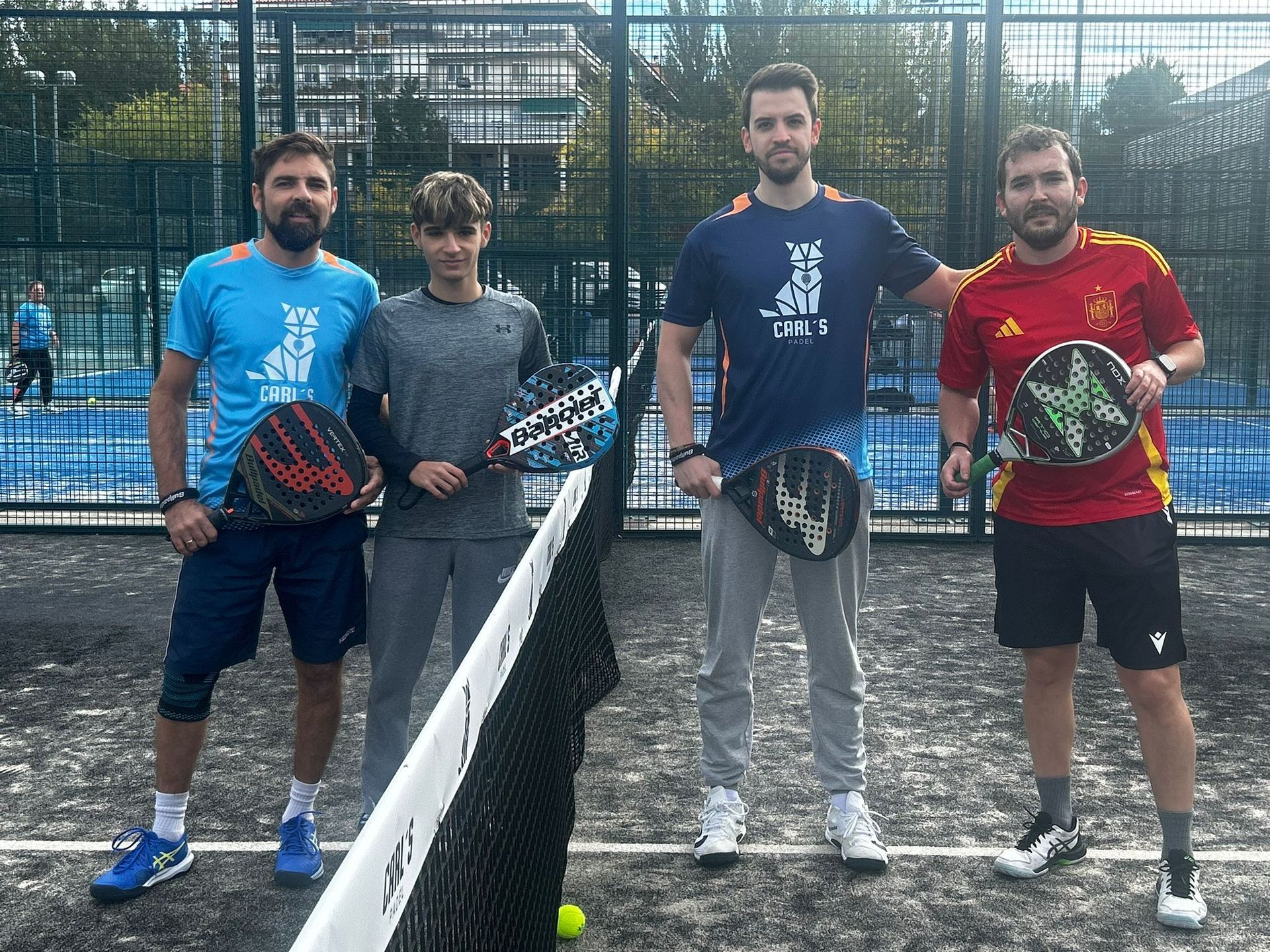 Un grupo de hombres están parados uno al lado del otro en una cancha de tenis sosteniendo raquetas de tenis.