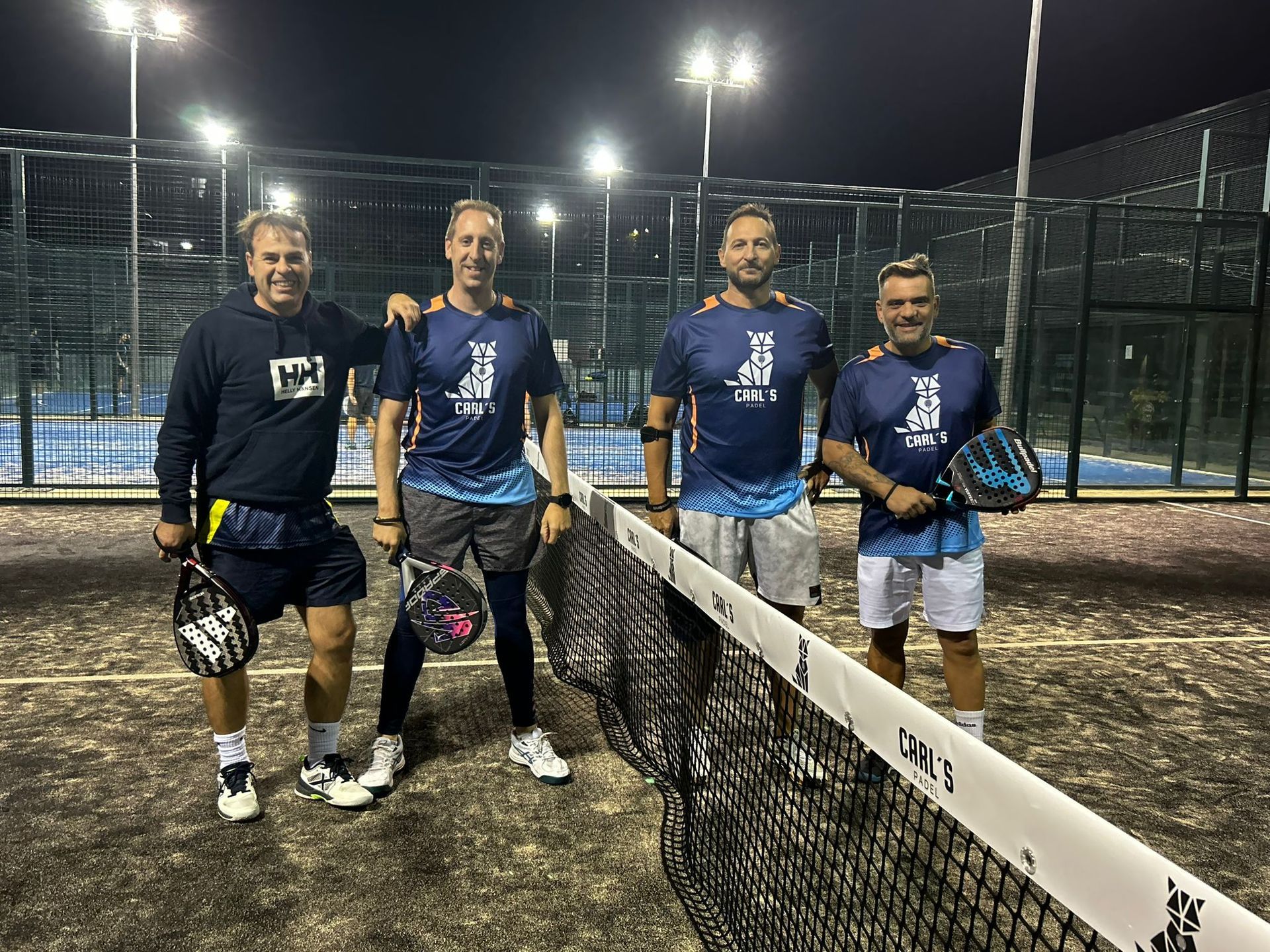 Un grupo de hombres posa para una fotografía en una cancha de tenis.