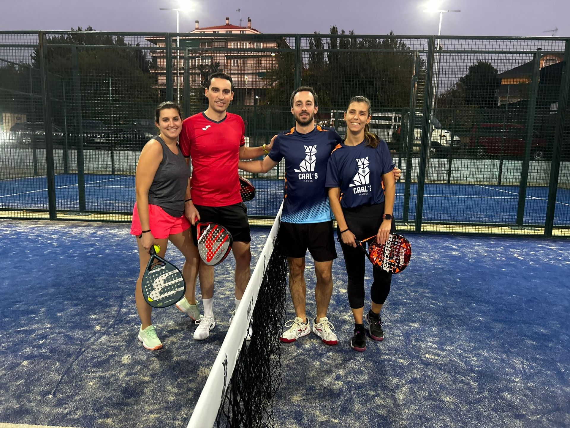 Un grupo de personas posa para una fotografía en una cancha de tenis.