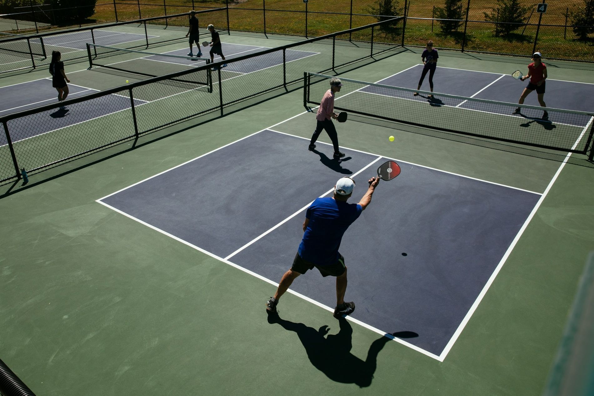 Un grupo de personas está jugando al tenis en una cancha.