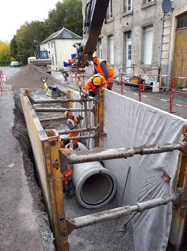 Grande tranchée avec un grand tuyau sous une route