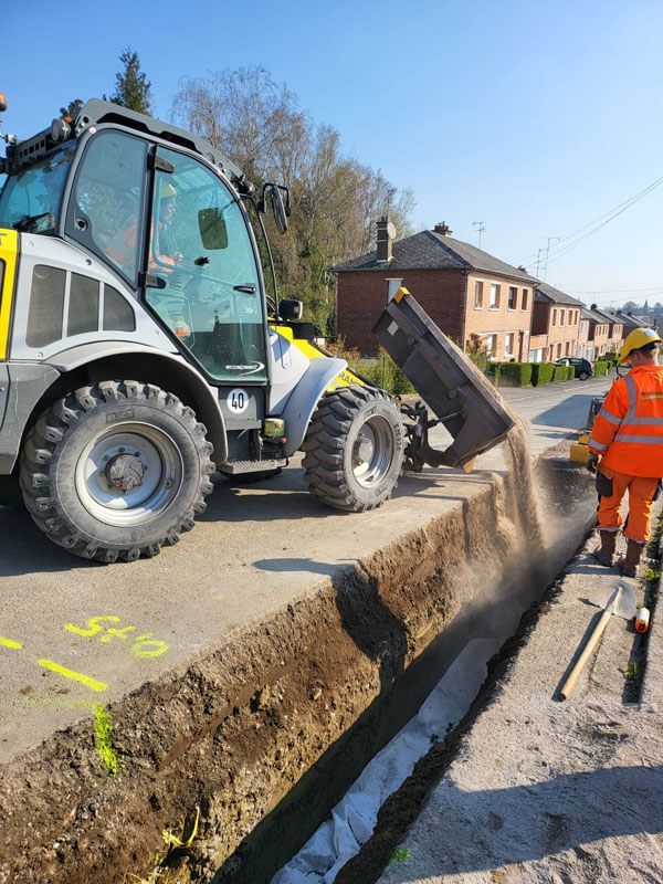 Chargeuse qui remplie une tranchée
