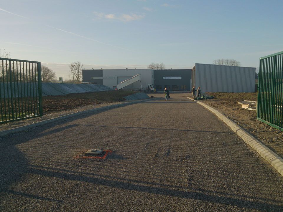 Entrée d'une entreprise avec une route enrobée avec des bordures