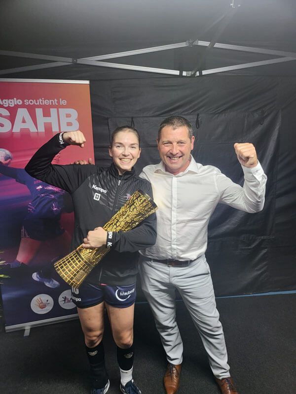 La joueuse Camille Aoustin qui tient la coupe de France de Handball avec M. Maréchal, dirigeant de Maréchal TPN