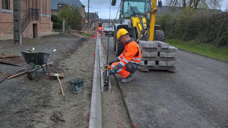 Pose d'une bordure le long d'une route