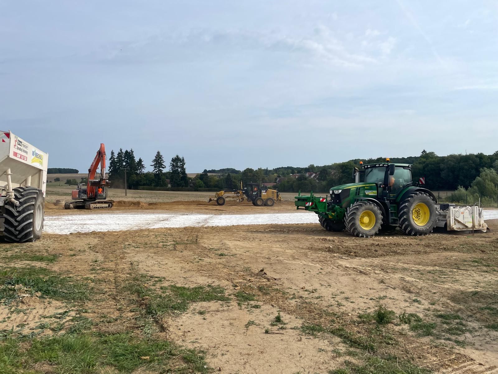 Deux tracteurs qui épandent de la chaux