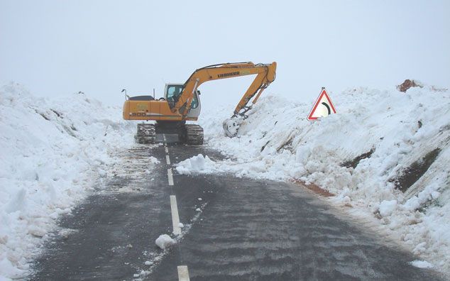 Pelle mécanique qui retire la neige d'une route enneigée