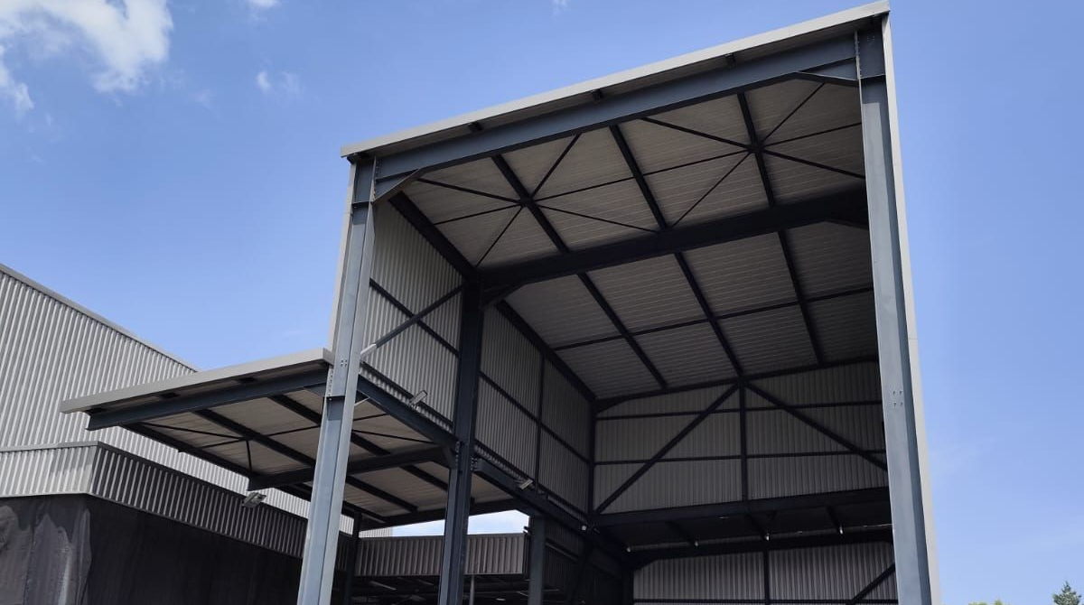 Bâtiment industriel à ossature métallique et toit en tôle ondulé.