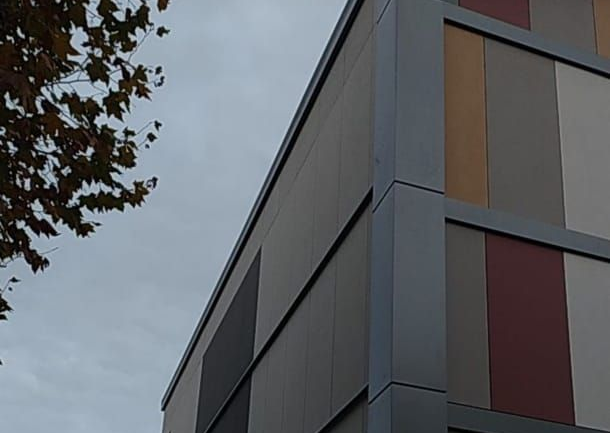 Façade d'un bâtiment moderne avec des panneaux multicolores.