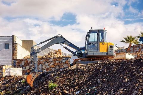 Ein Bagger bewegt Erde auf einer Baustelle.