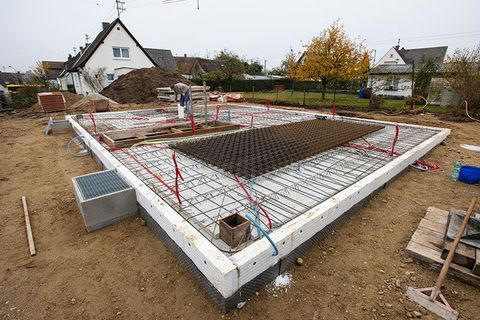 Auf einer Baustelle wird ein Betonfundament für ein Haus errichtet.
