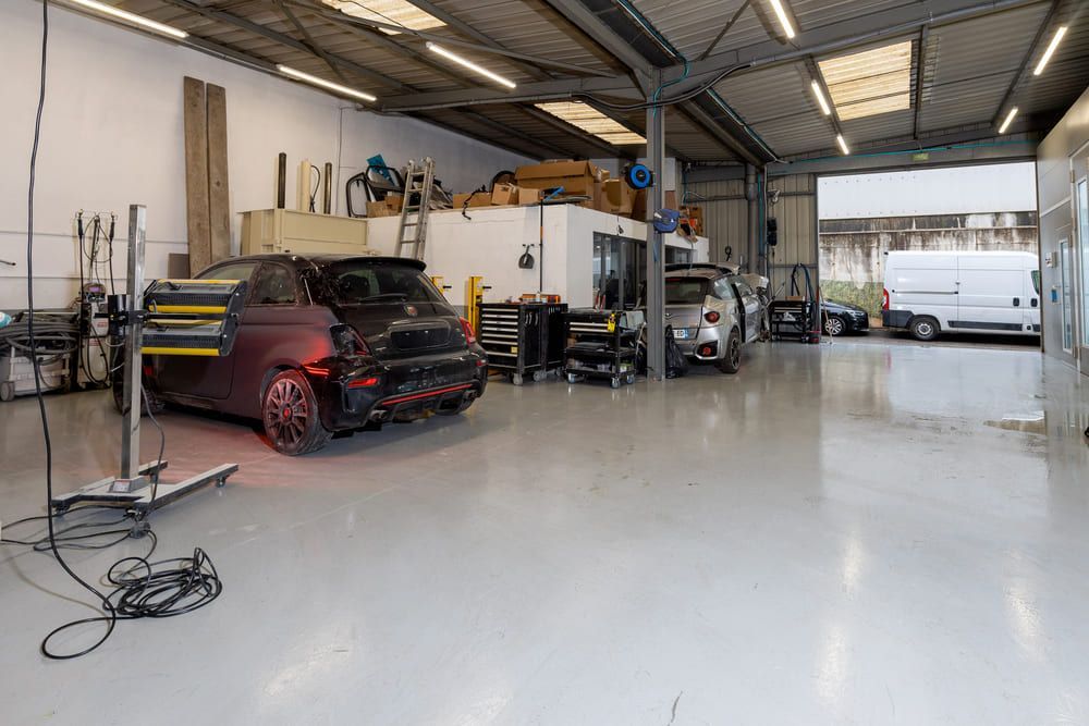 Garage vu de l'intérieur avec véhicules à réparer