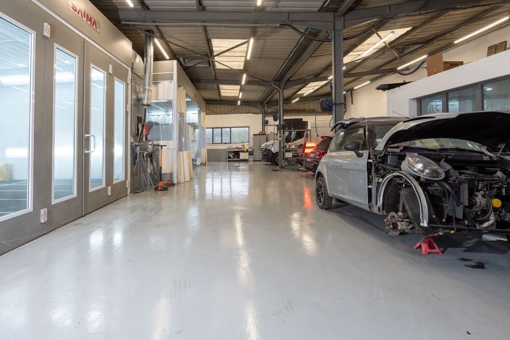 Intérieur de garage blanc avec véhicules à réparer