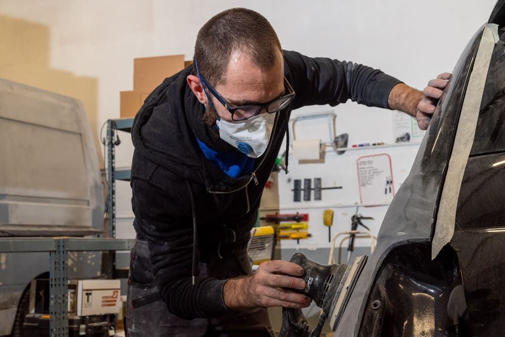 Mécanicien travaillant sur une carosserie noire