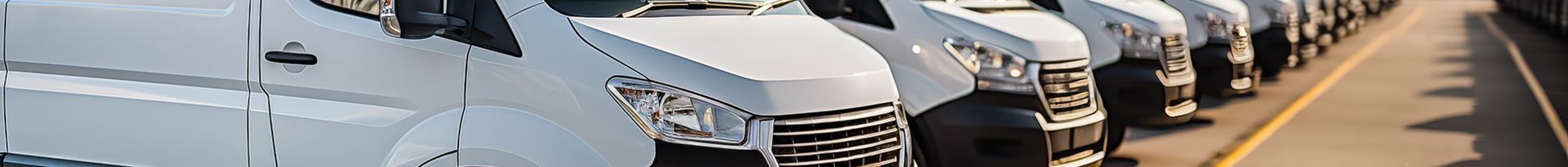 Plusieurs véhicules utilitaires blanc garés les uns à côté des autres