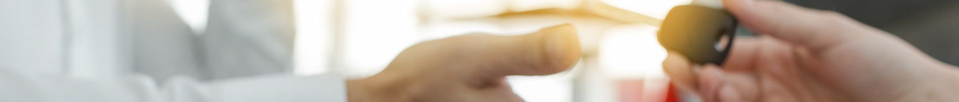 Les mains d'un mécanicien soulevant un capot bosselé