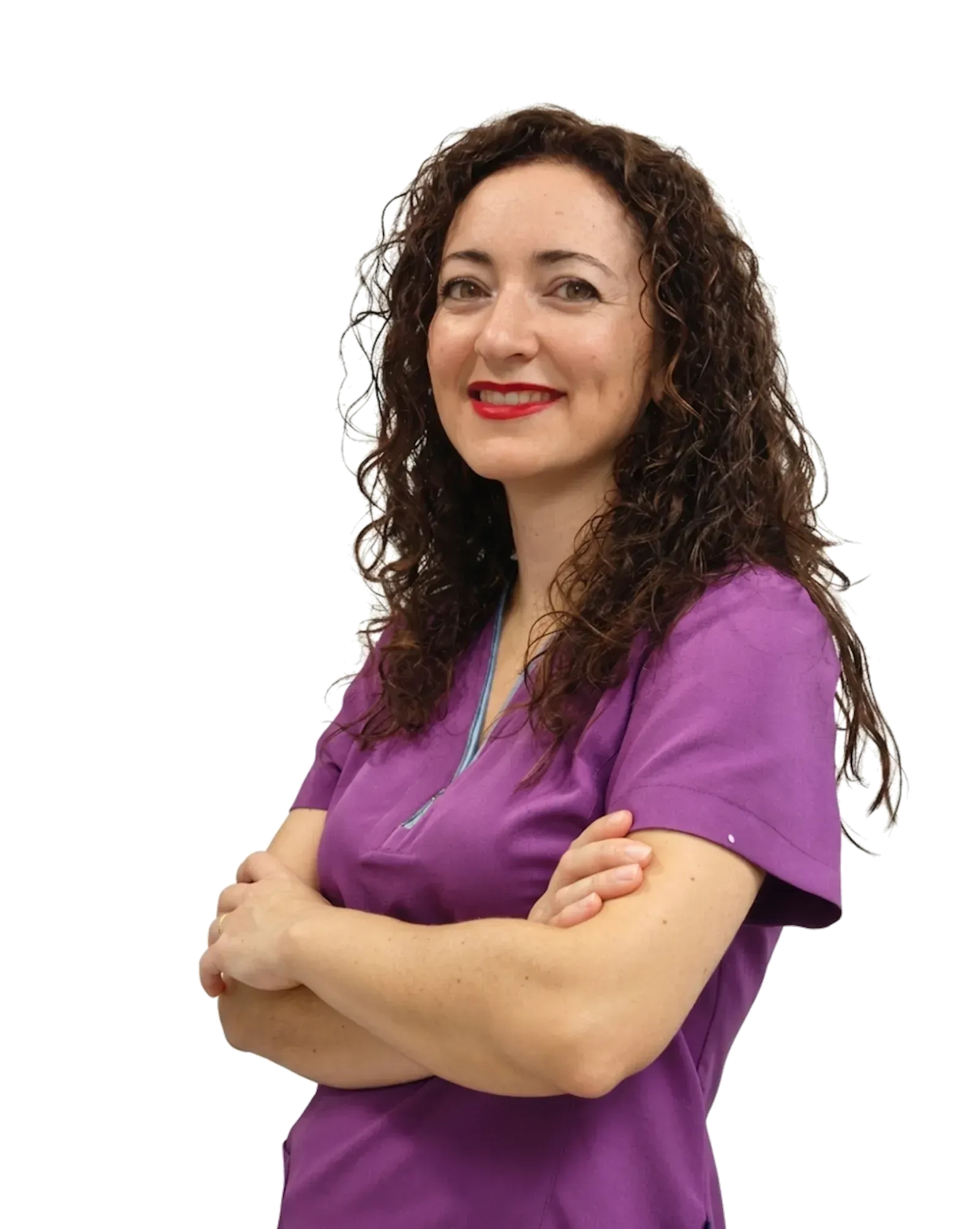 Persona sonriente con una blusa morada y los brazos cruzados, de pie sobre un fondo blanco.
