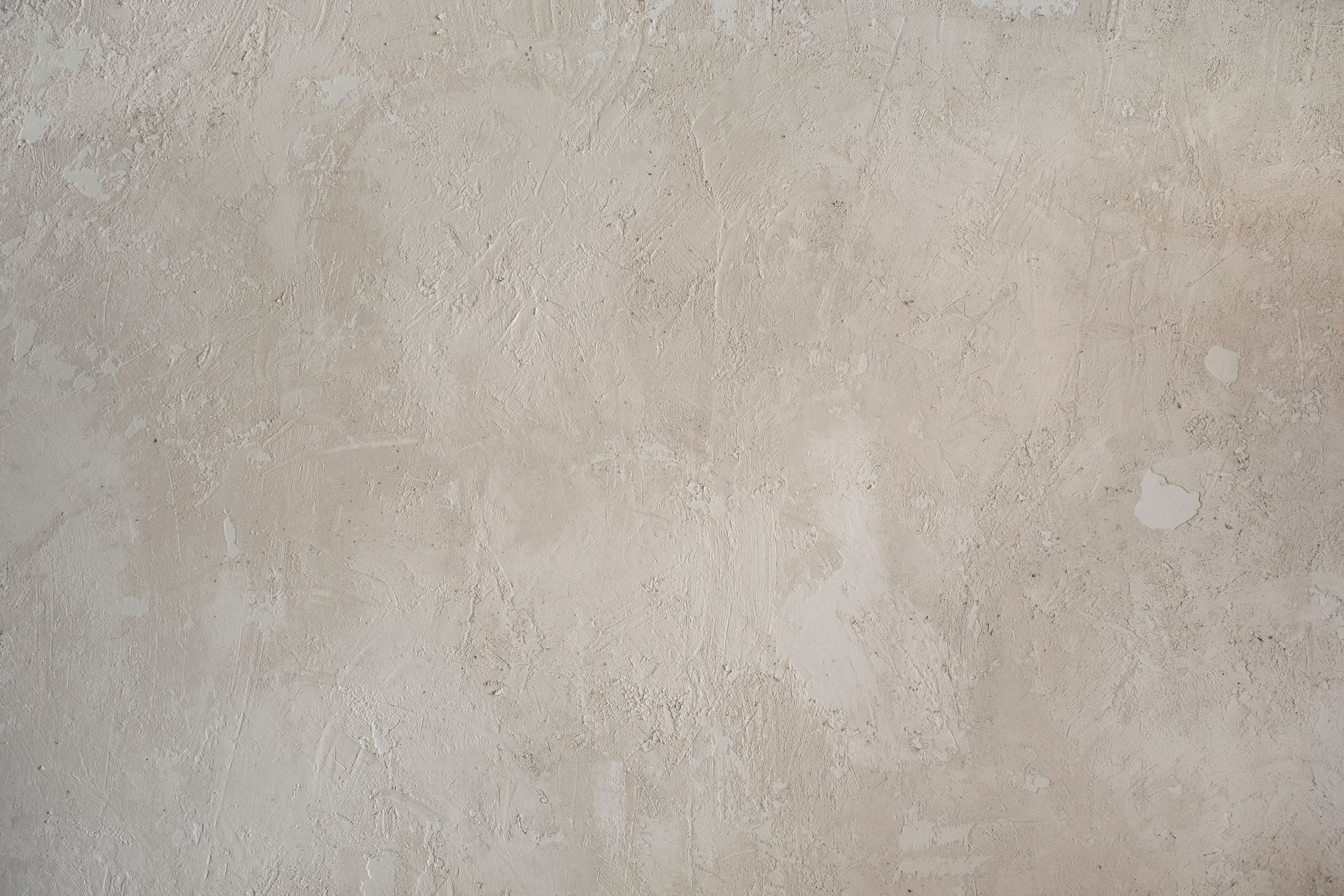 Mur en béton texturé beige avec un motif moucheté.