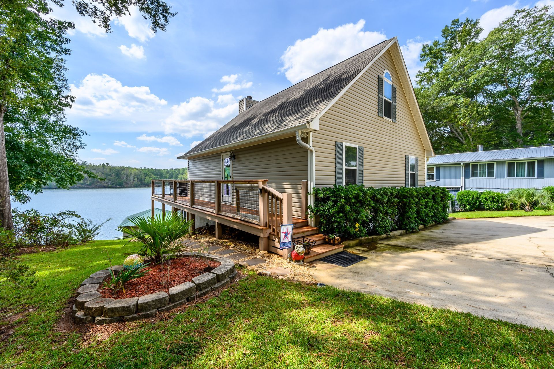 A house with a deck overlooking a lake. Lake Sinclair, lakefront, Georgia, vacation rental, short term rental, Eatonton, boating, fishing, fire pit, screened porch.