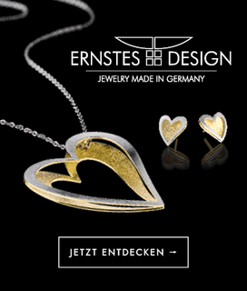 Silver and gold heart pendant necklace and earrings on black background. 