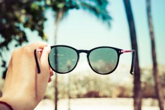 Sonnenbrille neben Palmen